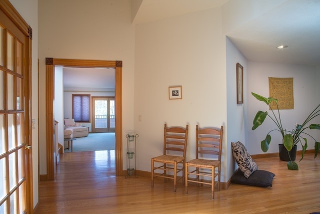 corridor featuring a towering ceiling and light hardwood / wood-style flooring