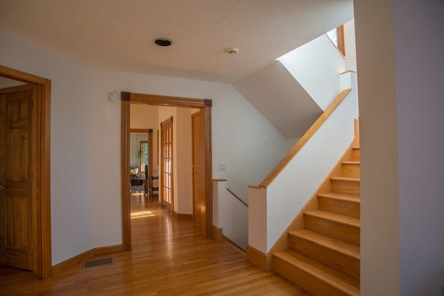 stairway with light hardwood / wood-style floors