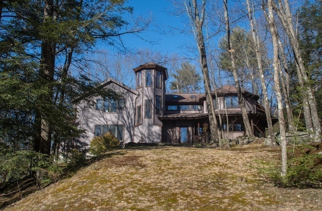 rear view of property featuring a lawn