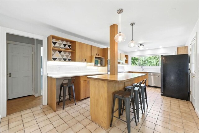 2 Silverwood Ter, South Hadley, MA 01075 - kitchen featuring stainless steel appliances, open shelves, a breakfast bar area, backsplash, and light tile patterned floors
