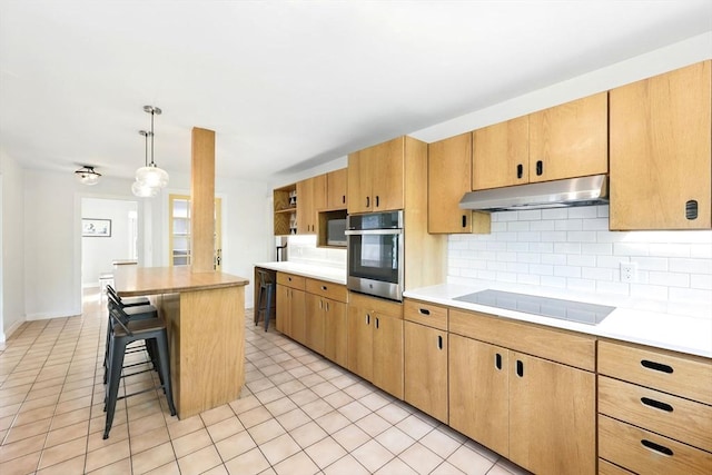 2 Silverwood Ter, South Hadley, MA 01075 - kitchen with under cabinet range hood, stainless steel oven, black electric stovetop, a breakfast bar area, and decorative backsplash