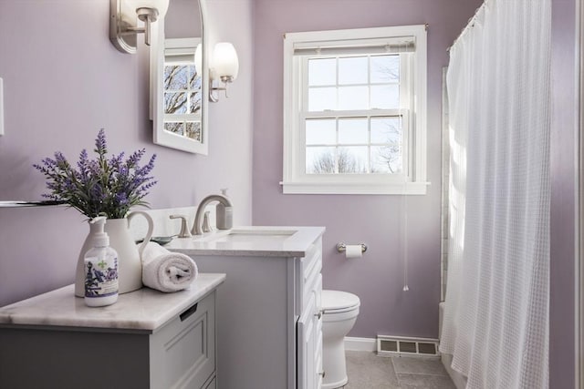 bathroom featuring vanity, toilet, and tile patterned flooring