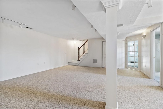 interior space featuring light colored carpet and track lighting