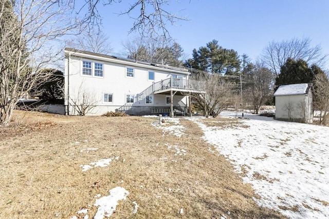 snow covered back of property featuring a wooden deck