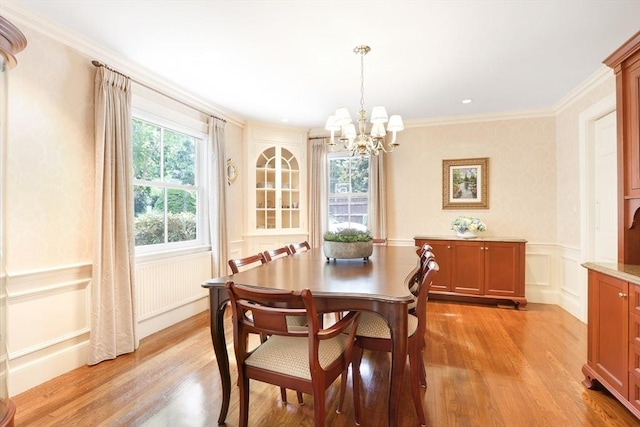 dining room with a wainscoted wall, crown molding, and light wood finished floors