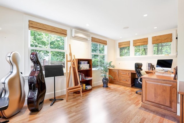 home office with light wood finished floors, built in desk, recessed lighting, and a wall unit AC