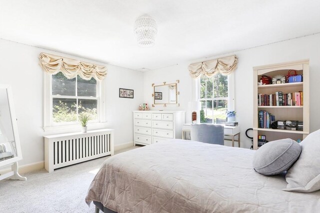 carpeted bedroom with radiator and baseboards