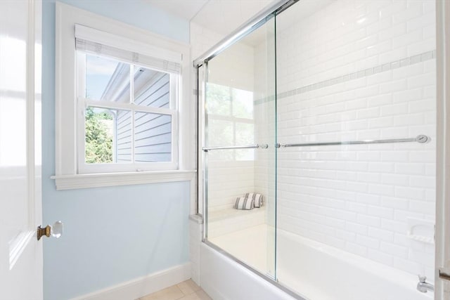 bathroom featuring tile patterned flooring, baseboards, and combined bath / shower with glass door