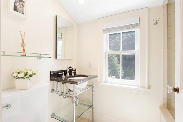 full bath with vaulted ceiling, toilet, a shower, and a sink