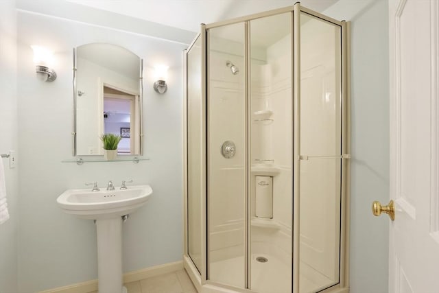 full bath with tile patterned floors, baseboards, and a stall shower