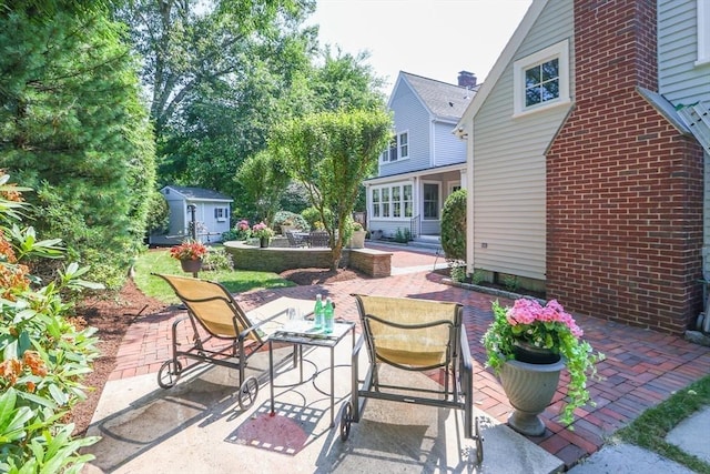 view of patio / terrace featuring outdoor dining space, an outdoor structure, and a shed