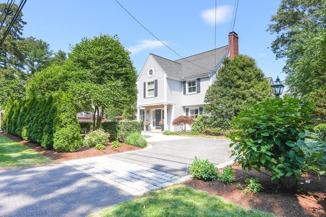 view of front of house with driveway and a chimney