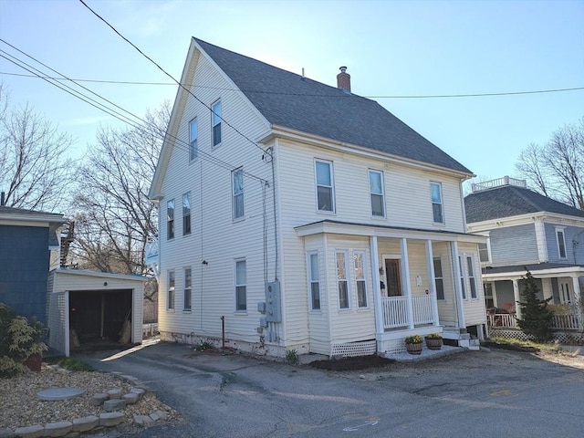 12-14 Essex St, Dover, NH 03820 - view of front facade with a chimney, an outdoor structure, covered porch, a detached garage, and a shingled roof
