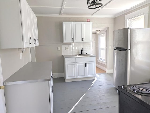 12-14 Essex St, Dover, NH 03820 - kitchen with freestanding refrigerator, a sink, white cabinetry, light wood-type flooring, and crown molding