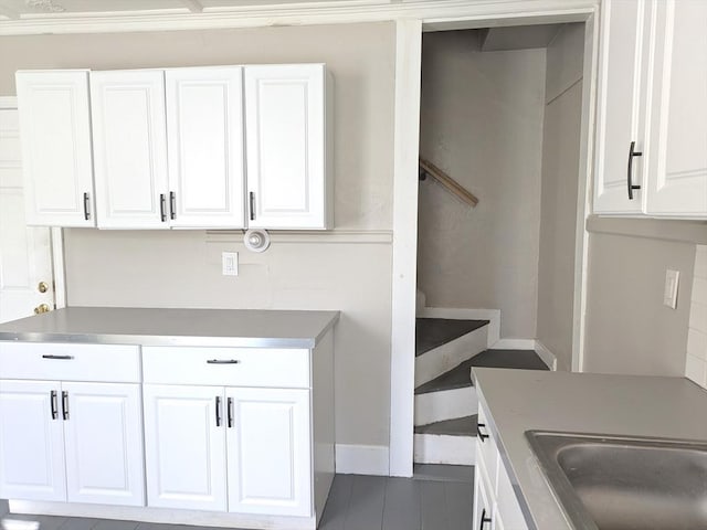 12-14 Essex St, Dover, NH 03820 - kitchen featuring white cabinetry, a sink, baseboards, dark tile patterned floors, and light countertops