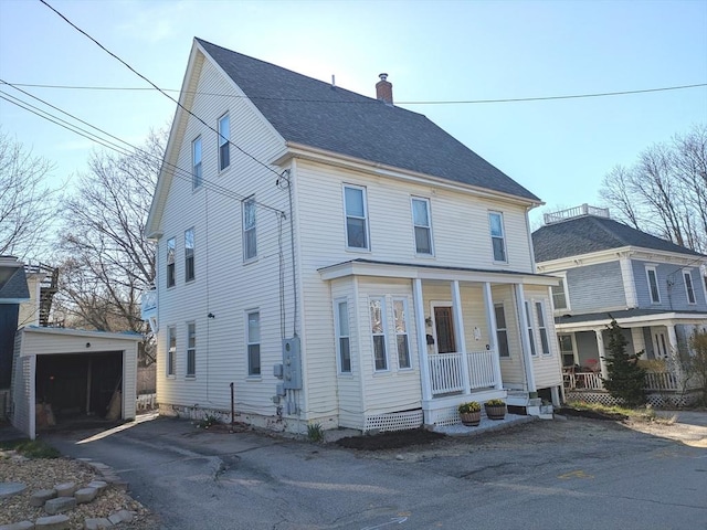12-14 Essex St, Dover, NH 03820 - view of front facade featuring an outbuilding, a chimney, covered porch, a detached garage, and a shingled roof