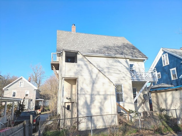 12-14 Essex St, Dover, NH 03820 - rear view of house featuring fence, a balcony, a chimney, and a shingled roof