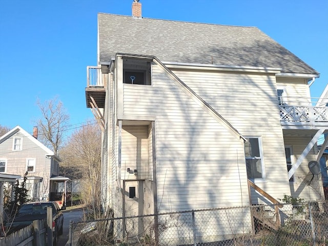 12-14 Essex St, Dover, NH 03820 - view of home's exterior featuring fence, roof with shingles, and a chimney