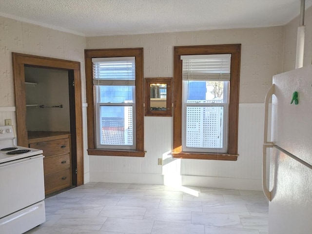 12-14 Essex St, Dover, NH 03820 - unfurnished dining area featuring plenty of natural light, a wainscoted wall, and a textured ceiling