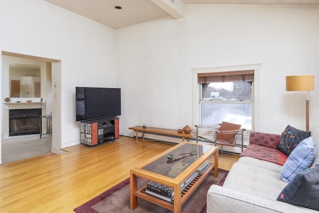 living room featuring hardwood / wood-style flooring, baseboard heating, and vaulted ceiling with beams