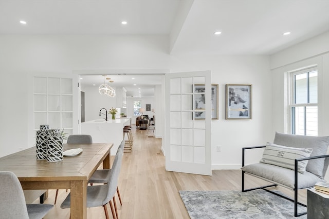 interior space with an inviting chandelier, sink, and light wood-type flooring