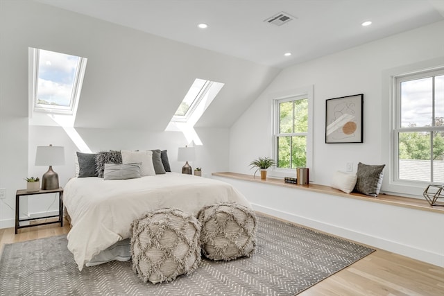 bedroom featuring wood-type flooring and lofted ceiling with skylight