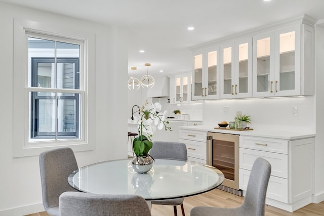 dining room with beverage cooler and light hardwood / wood-style floors