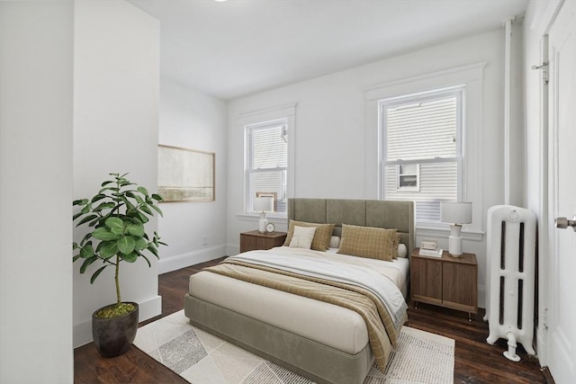 bedroom featuring radiator heating unit and dark hardwood / wood-style floors