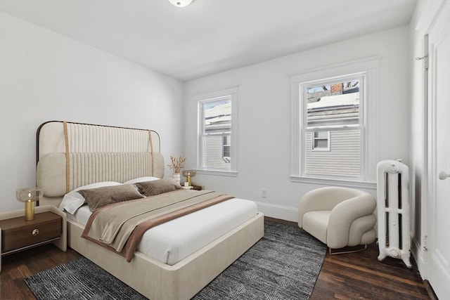 bedroom with radiator heating unit and dark hardwood / wood-style floors