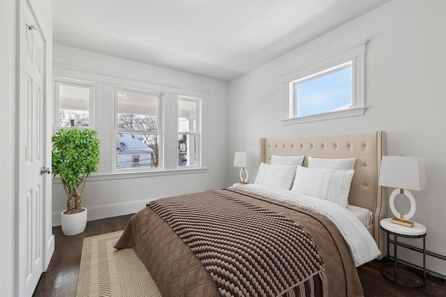 bedroom featuring dark hardwood / wood-style floors and a baseboard heating unit