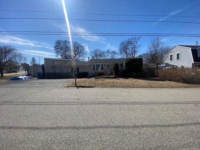 view of front facade with driveway and a shed