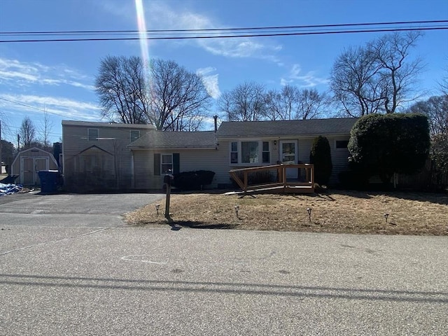 view of front of home with an outdoor structure, driveway, and a shed