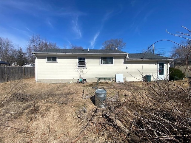 rear view of property featuring fence