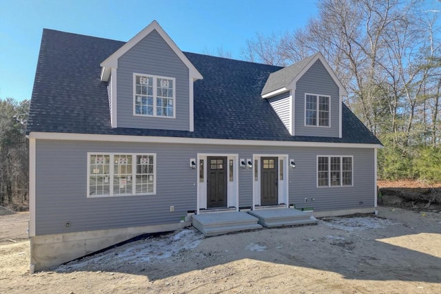 cape cod-style house with roof with shingles