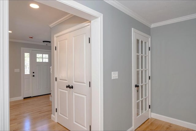 corridor featuring baseboards, ornamental molding, and light wood finished floors