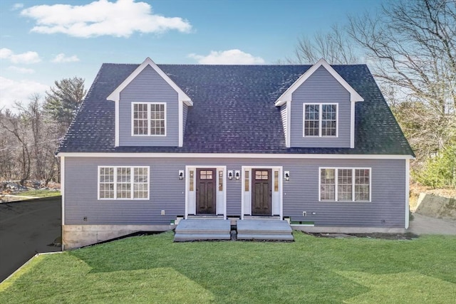 cape cod house featuring a front yard and roof with shingles