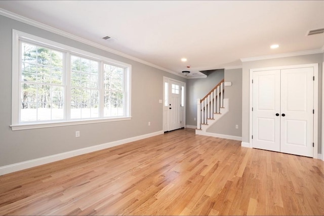 foyer with stairway, visible vents, baseboards, light wood-style floors, and crown molding