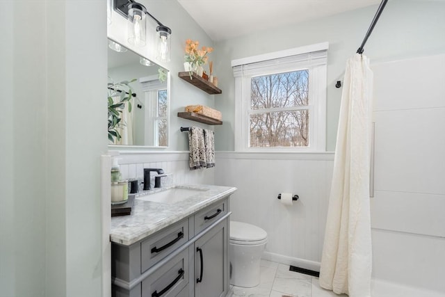 bathroom with a wainscoted wall, visible vents, toilet, marble finish floor, and vanity