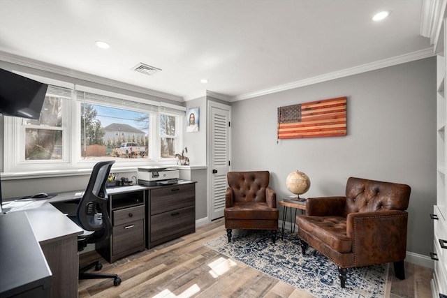 office featuring visible vents, baseboards, ornamental molding, and light wood-style flooring