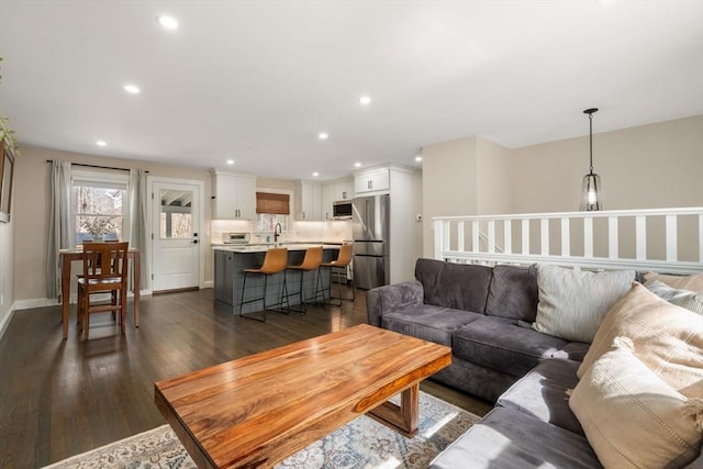 living room with recessed lighting, baseboards, and dark wood-type flooring