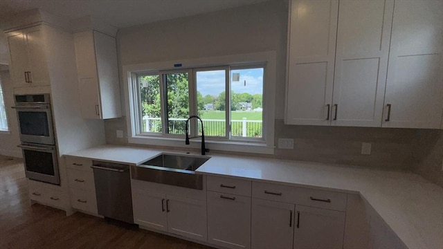 7 Avery St, Needham, MA 02494 - kitchen featuring stainless steel double oven, dishwasher, a sink, and white cabinetry