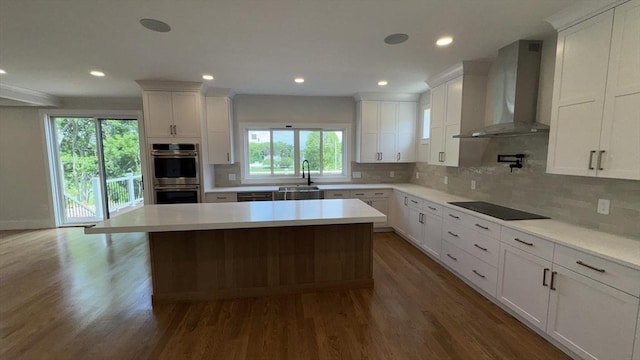 7 Avery St, Needham, MA 02494 - kitchen with wall chimney exhaust hood, stainless steel double oven, a sink, dark wood-type flooring, and light countertops