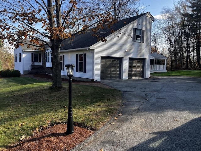 view of front facade with aphalt driveway, a front lawn, and a garage