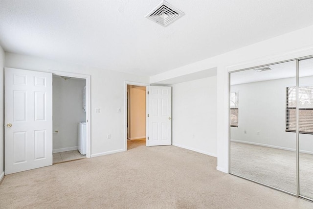 unfurnished bedroom featuring light carpet and a closet