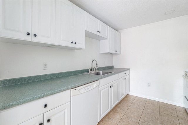 kitchen with white dishwasher, light tile patterned floors, sink, and white cabinets