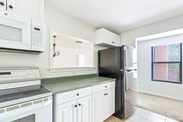 kitchen featuring white cabinetry, white appliances, a textured ceiling, and light tile patterned floors