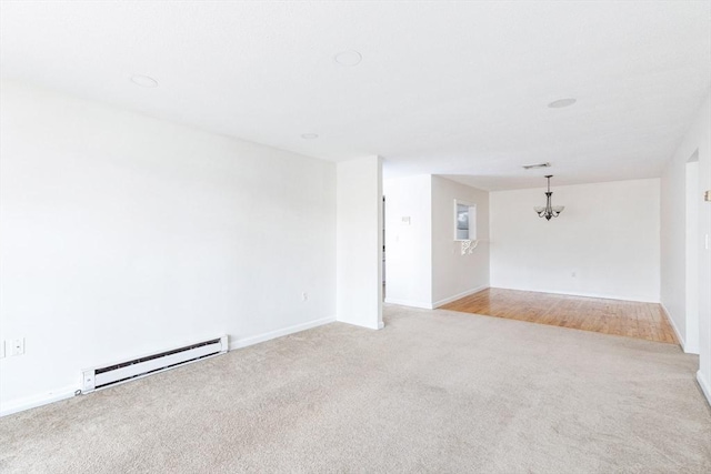 empty room with baseboard heating and light colored carpet