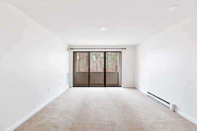 carpeted empty room featuring a baseboard radiator and a textured ceiling