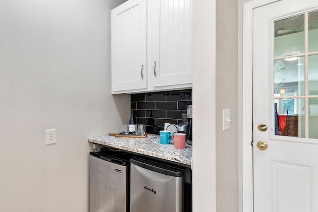 bar area with fridge and tasteful backsplash
