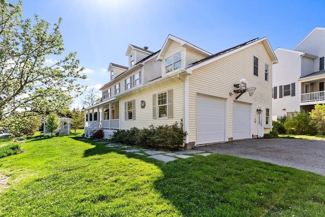 view of home's exterior with asphalt driveway, a yard, covered porch, and a garage